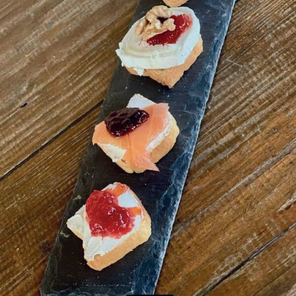 Tostas de carne madurada con diferentes toppings en tabla de madera.