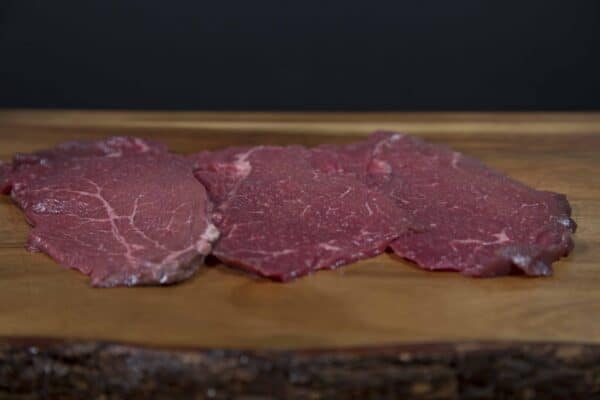 Carne natural madurada de res en tabla de madera para Delirio Res.